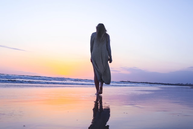 海辺を寂しく歩く女性
