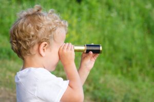 望遠鏡で何かを見ている子供